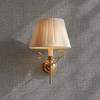 Close up of grey burlap linen wallpaper with printed woven texture and brass sconce