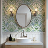 Sigrid Sage Nordic Botanical Wallpaper in 26 inch repeat styled in a powder room with oval mirror, white wainscoting, brass sconces, and green botanical walls