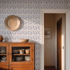 Angelique Blue Floral Wallpaper in 13 inch repeat styled in a farmhouse hallway with wood cabinet, wall plate, doorway, and medium blue floral wall pattern