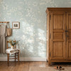 Celia Mint Botanical Wallpaper styled in a farmhouse bedroom with vintage wood armoire, chair, wall hooks, flowers, and soft mint floral wall decor
