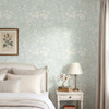Celia Mint Botanical Wallpaper styled in a bright bedroom with white bedding, nightstand, table lamp, soft curtains, and airy mint botanical walls