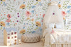 Eloise Wildflower Wallpaper styled in a girls bedroom with canopy bed, dollhouse, woven pouf, and colorful watercolor floral walls