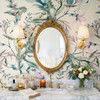 Eden Watercolor Floral Wallpaper in 52 inch repeat styled in a maximalist bathroom with gold oval mirror, brass sconces, marble vanity, flowers, and soft botanical wall decor
