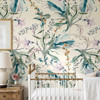 Eden Watercolor Floral Wallpaper styled in a girls nursery with brass crib, white bedding, wood nightstand, and soft pastel botanical floral wallpaper