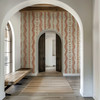 Elsie Sunbaked Clay floral stripe wallpaper in an entryway with white arches and a wood bench, 52 inch repeat