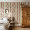 Elsie Sunbaked Clay floral stripe wallpaper in a farmhouse bedroom with a wood armoire, 52 inch repeat