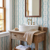 Elsie Aquamarine teal and ivory wallpaper beside a bathroom vessel sink and wood-framed mirror, 26 inch repeat