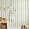 Elsie Ivory Mint Floral Stripe Wallpaper in Soft Nursery With Natural Wood Decor and Hanging Clothes