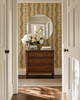 Elsie Walnut and Butter large-scale striped wallpaper in an English cottage entryway with an antique chest and white flowers