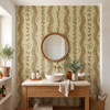 Warm brown botanical stripe wallpaper in a cottage powder room with a wood vanity, round mirror and brass wall sconces