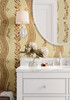 Close-up of warm brown floral stripe wallpaper in a cottage bathroom with a white vanity, curved mirror and glass wall sconce