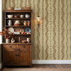 Brown and cream folk floral stripe wallpaper behind an antique dining room cabinet styled with pottery and autumn branches