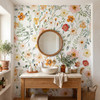 Madison wildflower wallpaper with large pink, yellow and cream blossoms around a round wooden mirror above a white vessel sink and natural wood bathroom vanity.