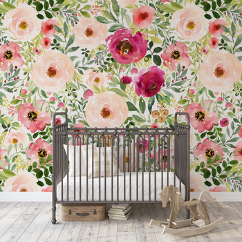 Jessica pink and red watercolor floral wallpaper in a nursery with a black metal crib and wooden rocking horse