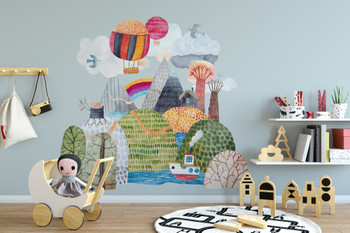 Large fairytale mountain castle watercolor wall decal with hot air balloons and rainbow displayed above a white nursery crib