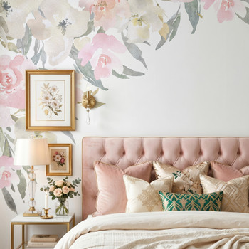 Blush pink watercolor floral canopy wall decal cascading beside a tufted pink headboard with framed botanical wall art