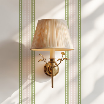 Charlotte Stripe wallpaper behind gold wall sconce showing delicate sage green and blush pink stripe detail