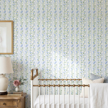 Soft cottage botanical stripe wallpaper shown behind a crib in a nursery room