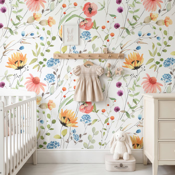 Eloise Wildflower Wallpaper styled in a nursery with white crib, wood shelf, baby clothes, rocking horse, and colorful wildflower wall pattern
