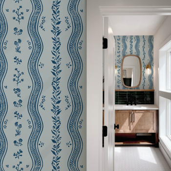 Elsie Delft Revival blue floral stripe wallpaper beside a bathroom doorway, showing the 52 inch repeat