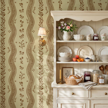 Brown and cream botanical stripe wallpaper behind a vintage white kitchen hutch styled with dishes, flowers and autumn accents