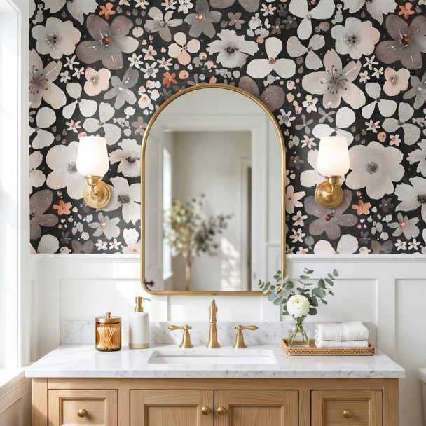 Skylar black floral wallpaper with oversized watercolor flowers in a bathroom with brass arched mirror, white vanity and warm wood accents