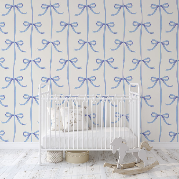 Light blue bow trellis wallpaper in a neutral nursery with white crib