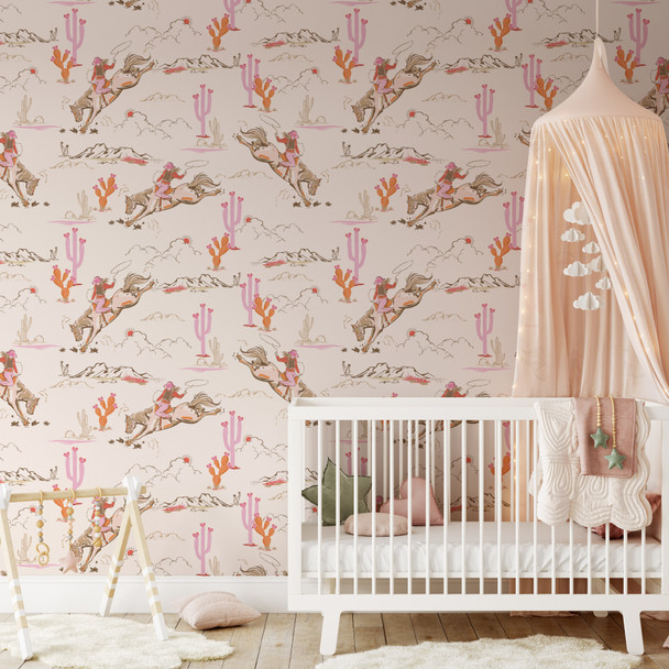 Pink western wallpaper for kids with vintage cowgirls, horses, and desert details in a nursery