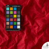 Red Dahlia waxed canvas with color calibration card on textured surface—rich crimson tone and classic waxed character