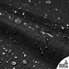 Detailed macro of 10oz cotton ripstop fabric in black, highlighting the water-repellent wax coating and distinctive grid texture