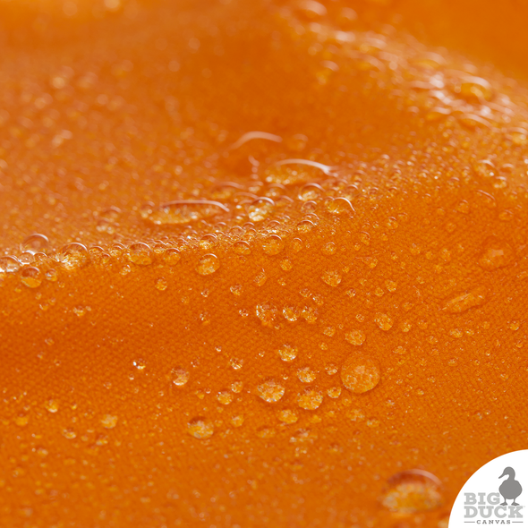 Water droplets beading on Marmalade orange Waxed Canvas Fabric — waterproof, non-toxic waxed cotton duck