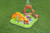 Children enjoying the Bestway Volcano Springs splash pool with dinosaur theme, volcano sprinkler and colourful play balls.