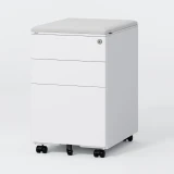 ofinto Büro-Korpus Weiss breit mit grauem Sitzkissen - breiter Schubladencontainer mit gepolstertem Sitzkissen in Hellgrau, 3 geräumigen abschließbaren Schubladen und Rollen, freistehend auf grauem Hintergrund