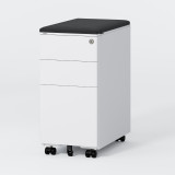 ofinto Büro-Korpus Weiss schmal mit schwarzem Sitzkissen - mobiler Schubladencontainer mit gepolstertem schwarzem Sitzkissen, 3 Schubladen mit Zylinderschloss und schwarzen Leichtlaufrollen, freistehend auf grauem Hintergrund