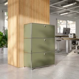 Cubox Büroregal mit 3 Ebenen und 3 Klappen in Olivgrün vor Holzlamellensäule im modernen Großraumbüro mit Schreibtischen