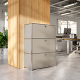 Cubox Büroregal mit 3 Ebenen und 3 Klappen in Seidengrau vor Holzlamellensäule im modernen Großraumbüro mit Schreibtischen