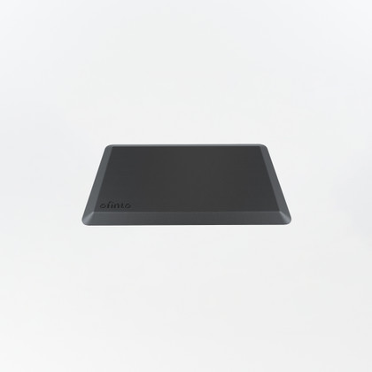 ofinto Ergonomische Stehmatte Schwarz - Schrägansicht der schwarzen Anti-Ermüdungsmatte mit ofinto Logo für Stehschreibtische auf hellem Hintergrund