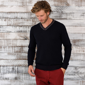 Man wearing a navy v neck cashmere sweater.