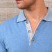 A detail shot of a man wearing a blue colored Pima cotton polo.