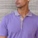 A detail shot of man wearing a purple colored polo with a striped collar.