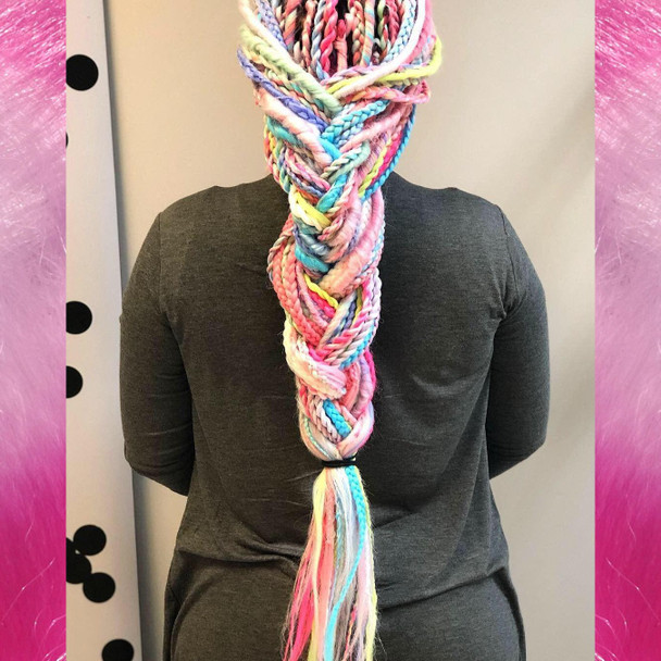 Alison wearing a mix of braids, twists, and wrapped dreads made from Mood Braid in Ice Sickle, Icy Blue, Italian Ice, and Pink Lemonade, and Festival Braid in Neon Pink, Candyfloss, Mojito, Pale Blue, Pastel Blue, Pure White, Rainbow, Sea Lavender, and Snow Pink