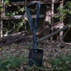 The U.S. Issue AMES Tri-fold Shovel in the ground unfolded
