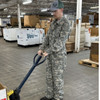 man pulling a hand truck wearing a Military Issue Mechanics Coveralls, UCP/ACU