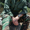 Man sitting on a rock wearing the Olive BDU jacket shirt