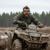 a person covered in mud on a ATV wearing military goggles