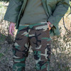 Man in the woods with one hand in pocket wearing the Tru-Spec Original GSA BDU Pant
in the color woodland camo