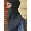 Man wearing the U.S. Issue Anti-flash Hood Flame Resistant standing infront of a brick wall 