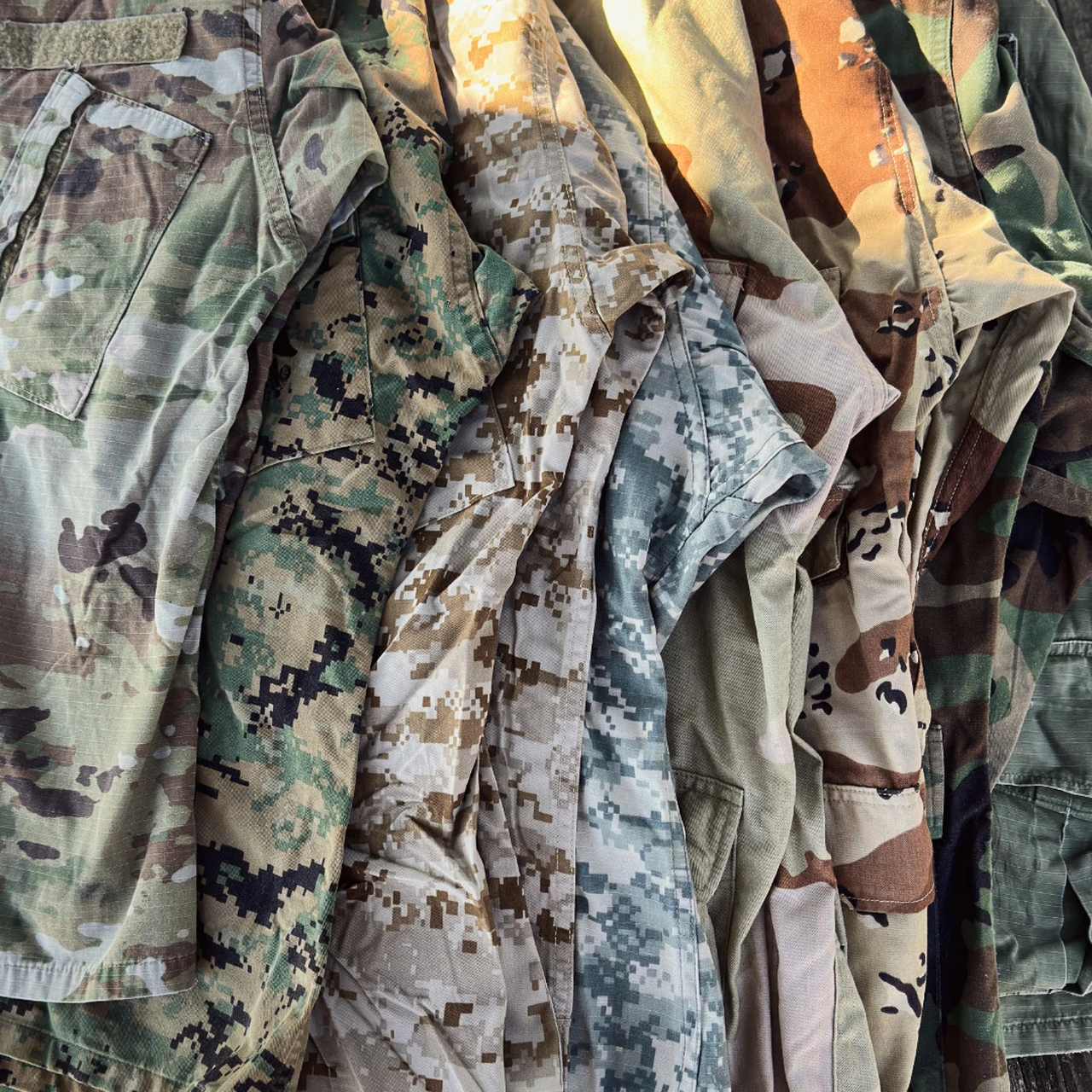 Rack of military camouflage uniforms in woodland, desert and digital patterns