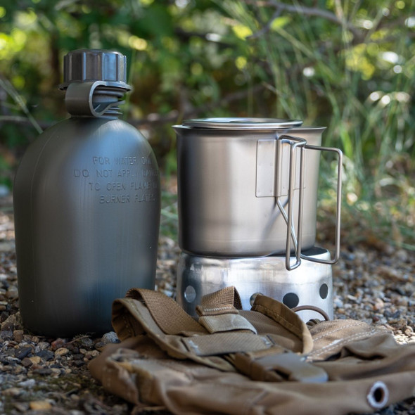 1 qt canteen, cup, and stove in the grass with the coyote pouch  1 qt canteen, cup, and stove in the grass with the coyote pouch