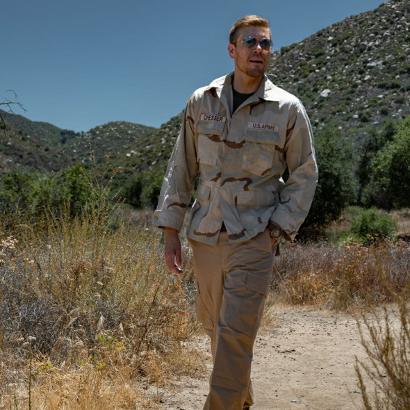 man walking in a desert us issue bdu top and coyote color bdu pant on a mesa trail man walking in a desert us issue bdu top and coyote color bdu pant on a mesa trail